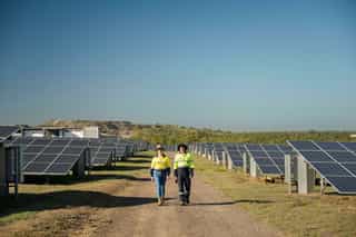 SamcoCollinsvilleSolar2024_workers facing towards camera walking solar panels on both sides.jpg